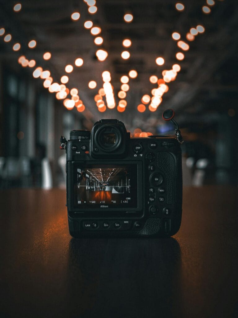 A DSLR camera on a table with creative bokeh lights in the background, perfect for photography enthusiasts.